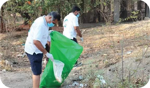 Volunteer handling filled garbage bags after collecting waste in a park